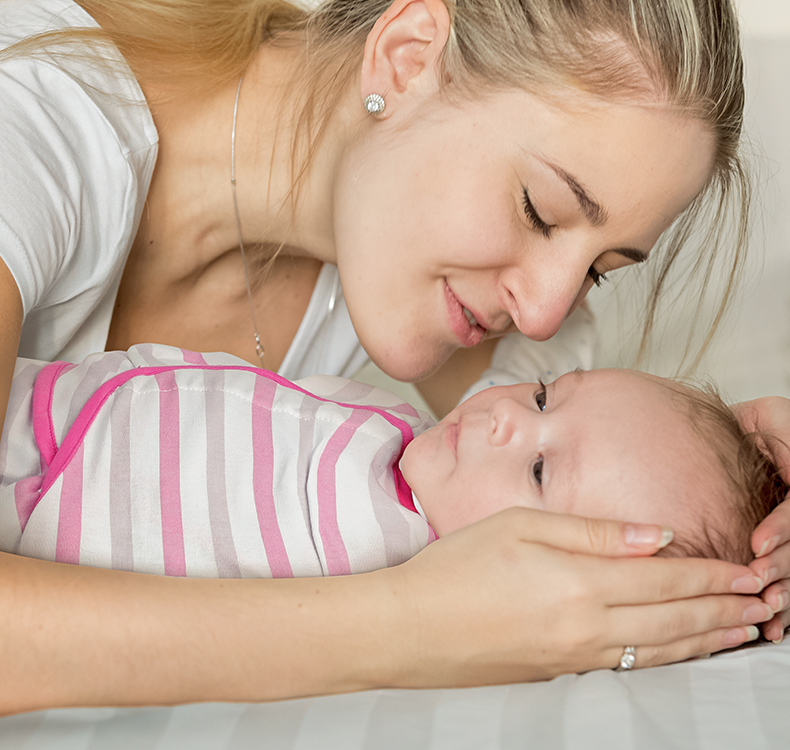 mom holding baby in organic swaddle